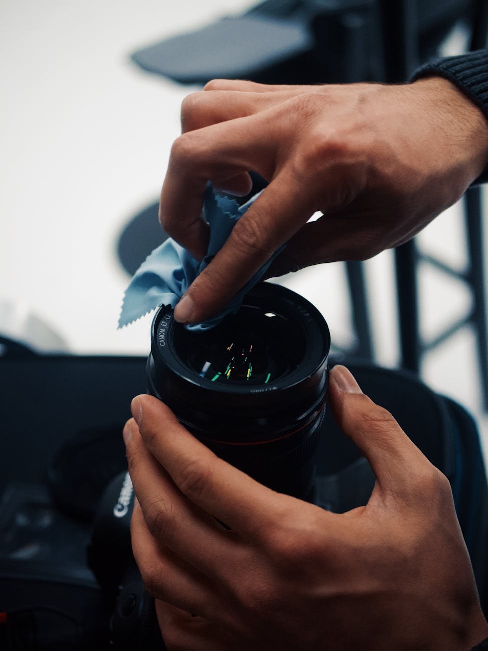 man cleaning camera lens