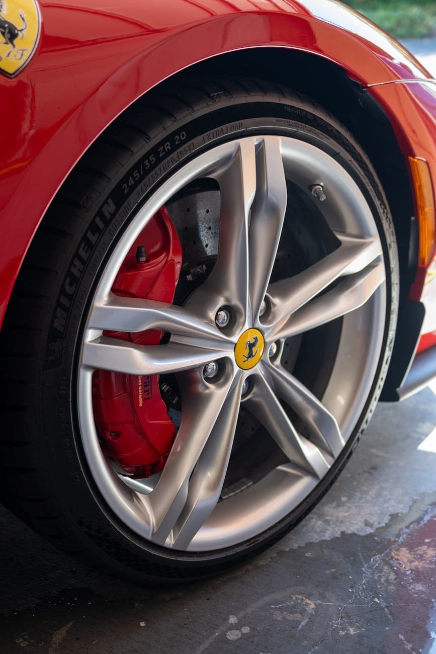 close up of sports car wheel with red brake caliper