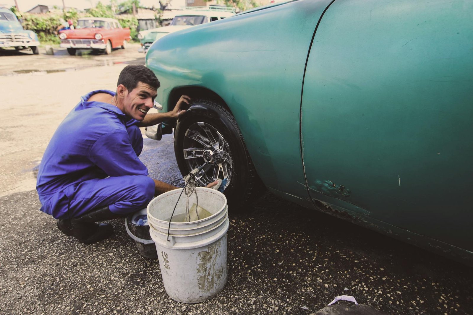 man cleaning the tire of a car