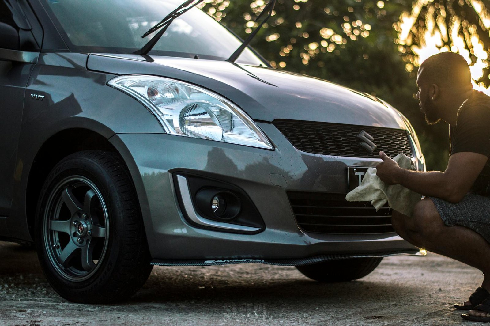 photo of man cleaning his car