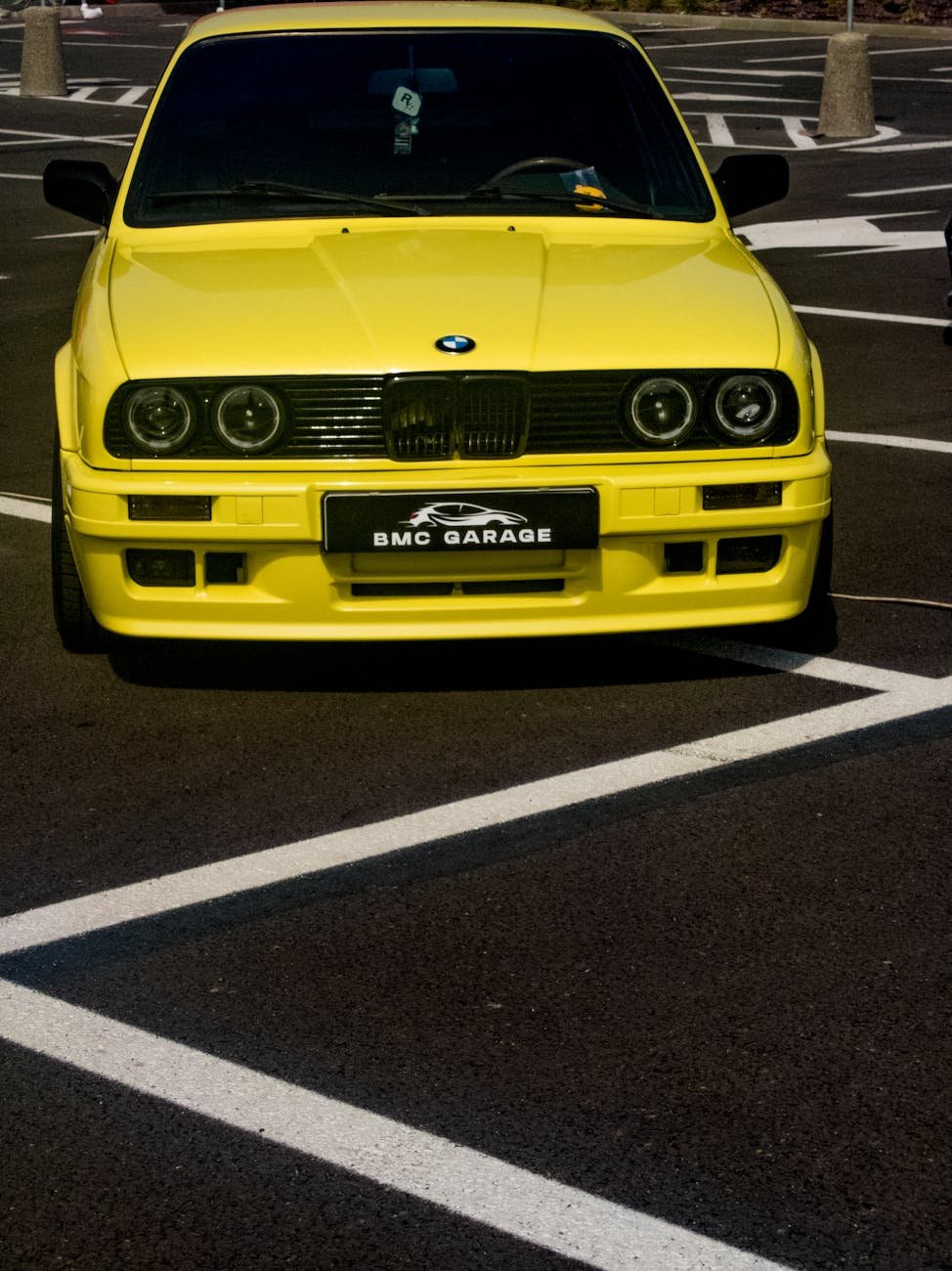 bright yellow classic car in empty parking lot