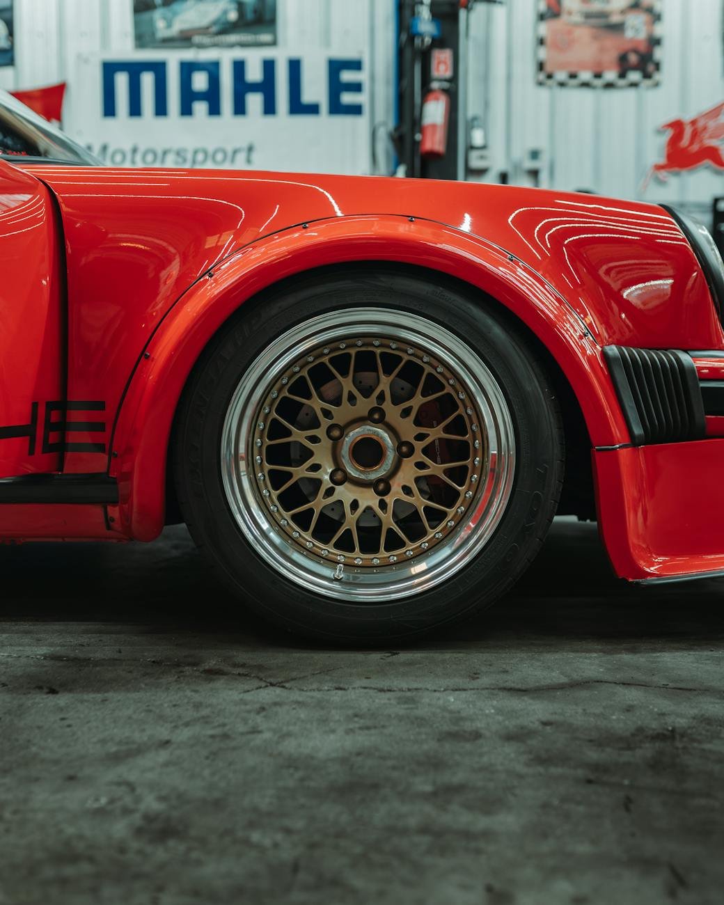 red porsche racecar in auto shop setting
