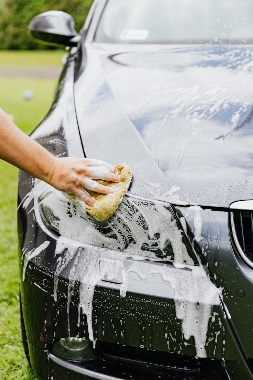 person cleaning a black car