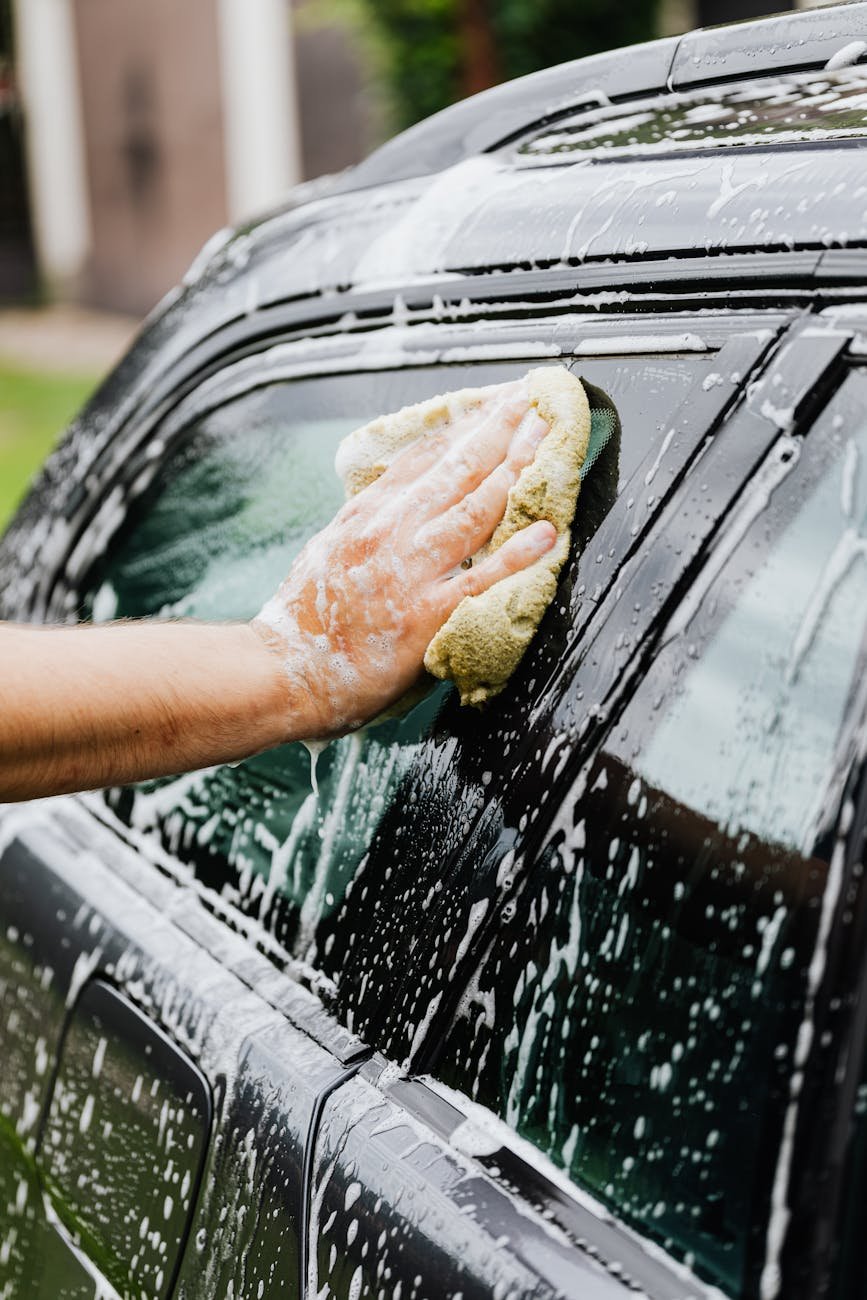 person washing a car with sponge