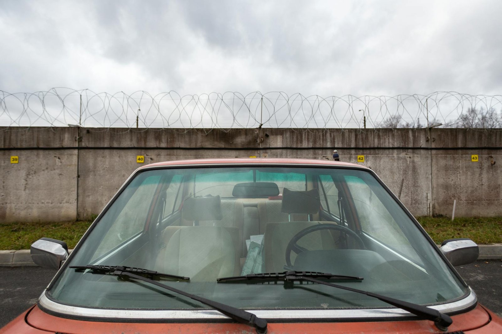 closeup photo of red car near concrete wall