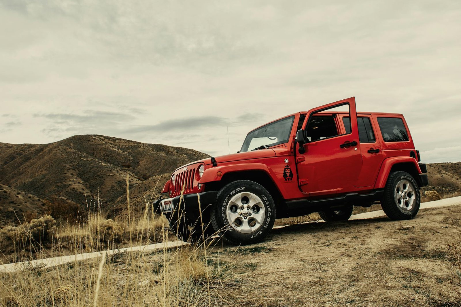 photo of red suv on dirt road